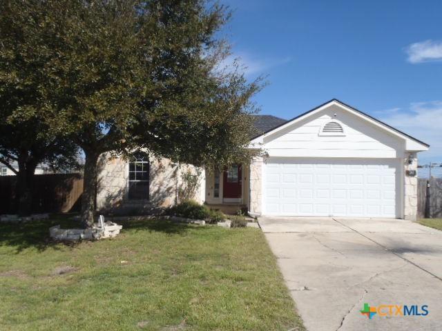 view of front of home with a garage, concrete driveway, and a front lawn