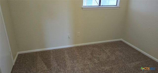 spare room featuring baseboards and carpet flooring