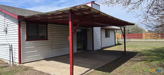 view of patio / terrace featuring an attached carport and fence