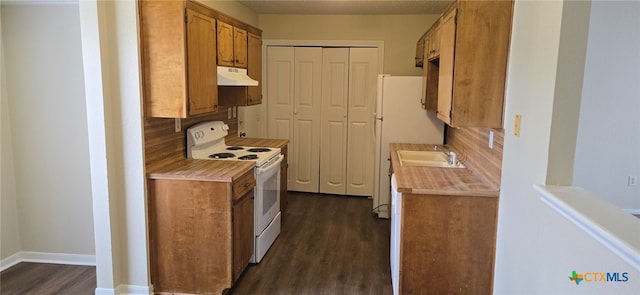 kitchen with electric range, decorative backsplash, light countertops, dark wood-type flooring, and under cabinet range hood