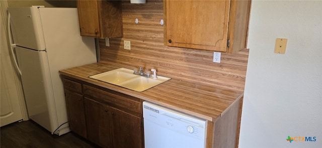 kitchen featuring white appliances, light countertops, and a sink