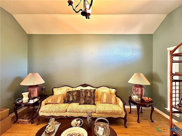 living area with light wood-style flooring, baseboards, and vaulted ceiling