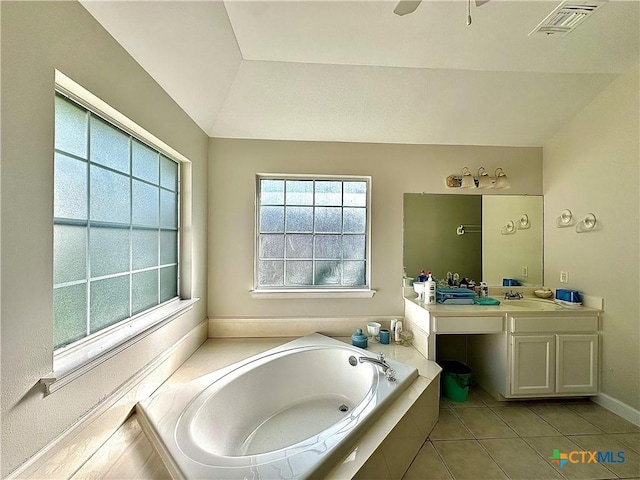 bathroom featuring vanity, tile patterned floors, visible vents, a bath, and lofted ceiling