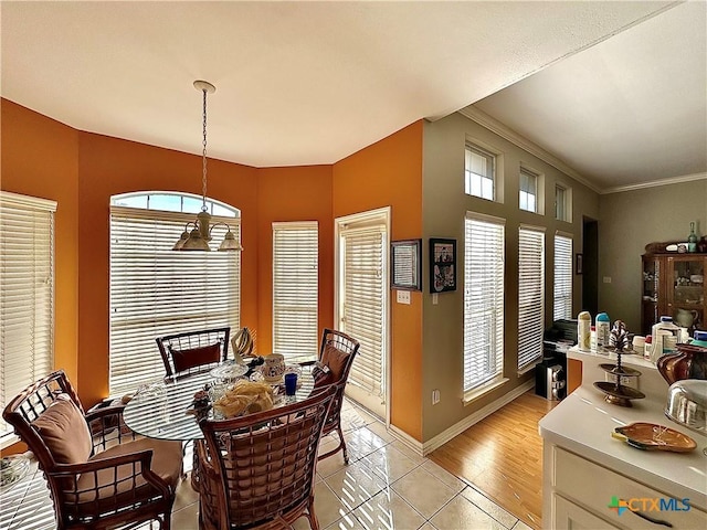 dining room featuring crown molding, light tile patterned floors, a notable chandelier, and a wealth of natural light