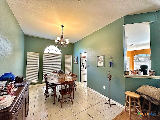 dining room with a notable chandelier, baseboards, visible vents, and light tile patterned flooring