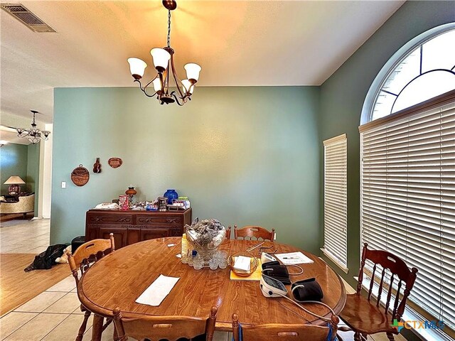dining room with visible vents, a notable chandelier, and light tile patterned floors