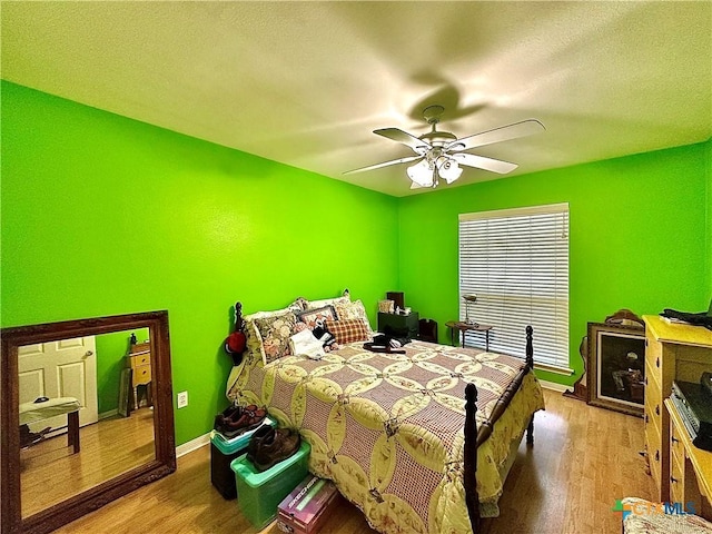 bedroom with baseboards, ceiling fan, and wood finished floors