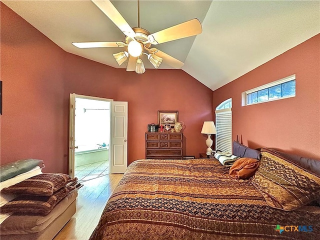 bedroom featuring ensuite bathroom, ceiling fan, wood finished floors, and lofted ceiling