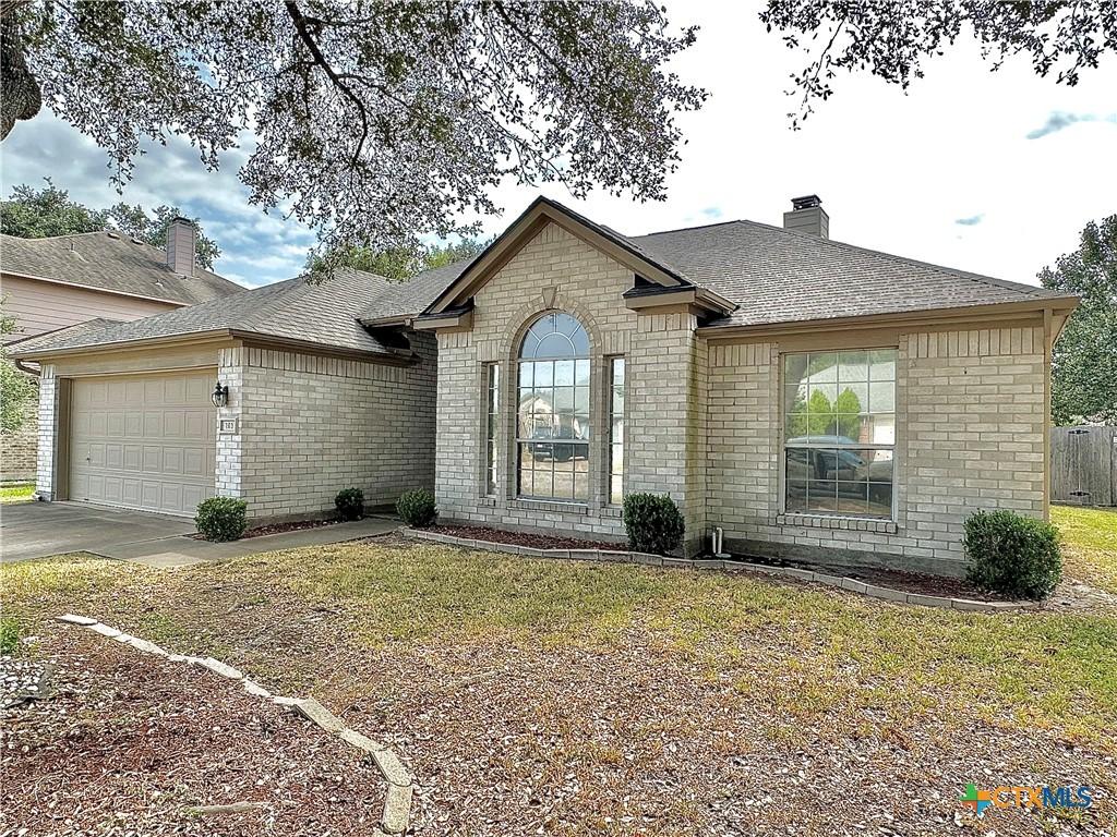 ranch-style home with a garage and a front lawn