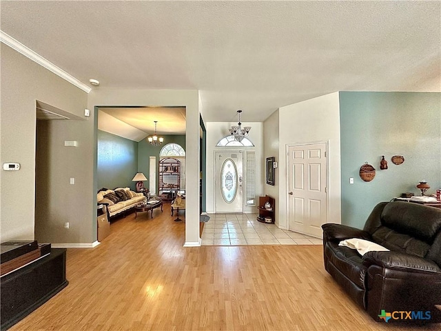 entrance foyer with light wood-style flooring, a chandelier, and baseboards
