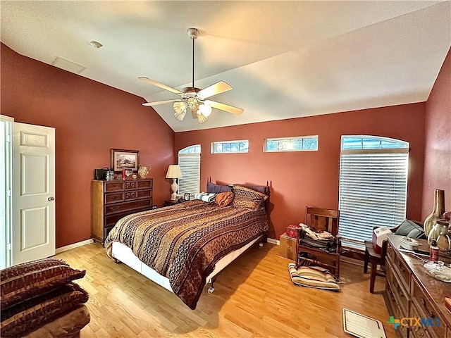 bedroom featuring light wood-style floors, baseboards, and vaulted ceiling