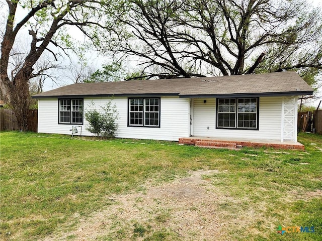 ranch-style house featuring a front yard and fence