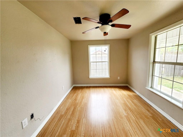 empty room featuring baseboards, light wood-style flooring, and ceiling fan