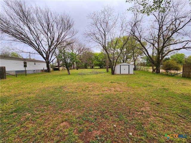 view of yard with an outdoor structure, a storage unit, and fence