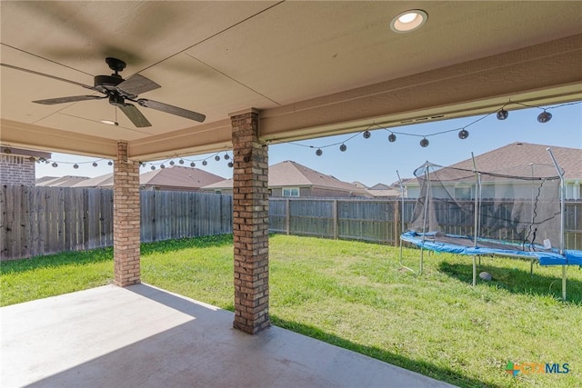 6106 Cactus Flower Ln, Killeen, TX 76549 - fenced backyard with a patio area, a trampoline, and a ceiling fan