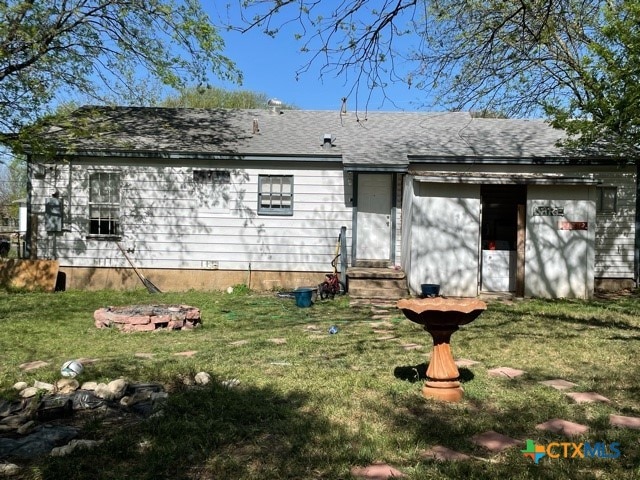 back of house featuring a lawn