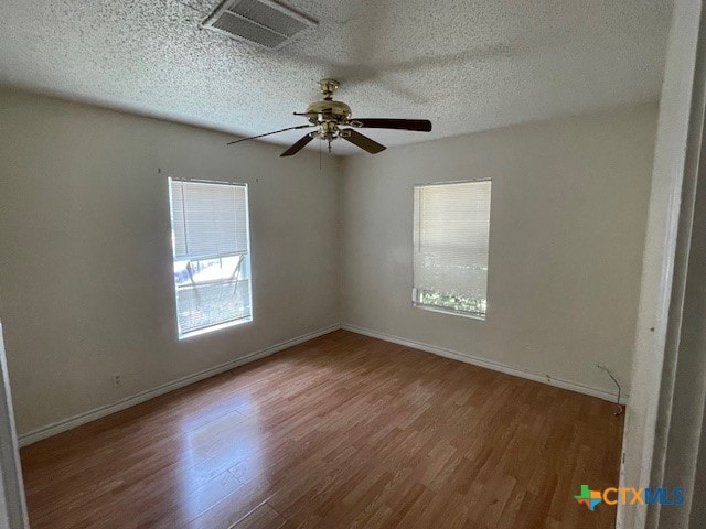 unfurnished room with hardwood / wood-style flooring, ceiling fan, and a textured ceiling