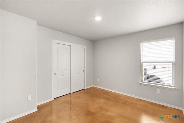 1402 Lindsey Dr, Copperas Cove, TX 76522 - unfurnished bedroom featuring finished concrete floors, baseboards, a closet, and recessed lighting