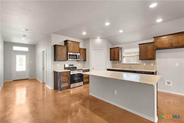 1402 Lindsey Dr, Copperas Cove, TX 76522 - kitchen with a center island, a sink, baseboards, appliances with stainless steel finishes, and tasteful backsplash