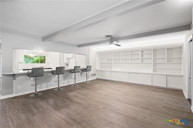 interior space featuring beamed ceiling, ceiling fan, and dark wood-type flooring