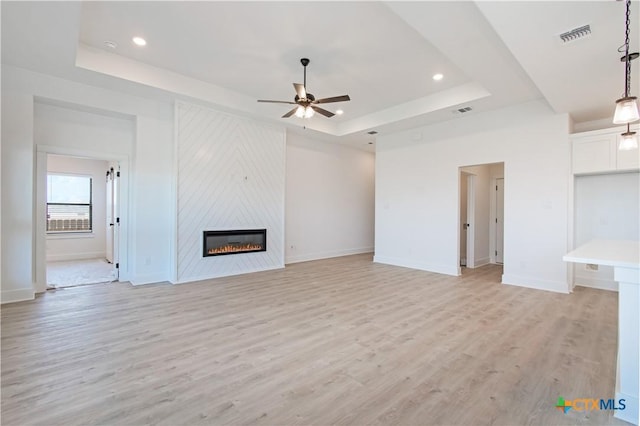 2002 Rosson St, Nolanville, TX 76559 - unfurnished living room featuring a raised ceiling, a ceiling fan, light wood-style floors, a large fireplace, and recessed lighting