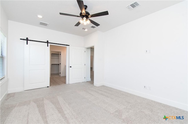 2002 Rosson St, Nolanville, TX 76559 - unfurnished bedroom featuring carpet, a walk in closet, a barn door, ceiling fan, and recessed lighting