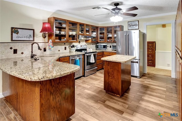 kitchen with kitchen peninsula, tasteful backsplash, a textured ceiling, stainless steel appliances, and sink