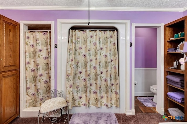 bathroom with toilet, ornamental molding, a textured ceiling, and walk in shower