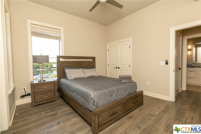 bedroom featuring dark wood-type flooring, a closet, ceiling fan, and ensuite bath