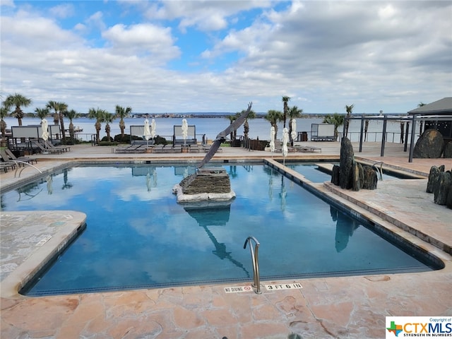 view of swimming pool with a water view and a patio area