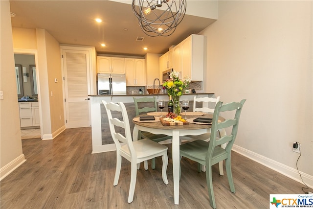 dining room with dark hardwood / wood-style floors and an inviting chandelier