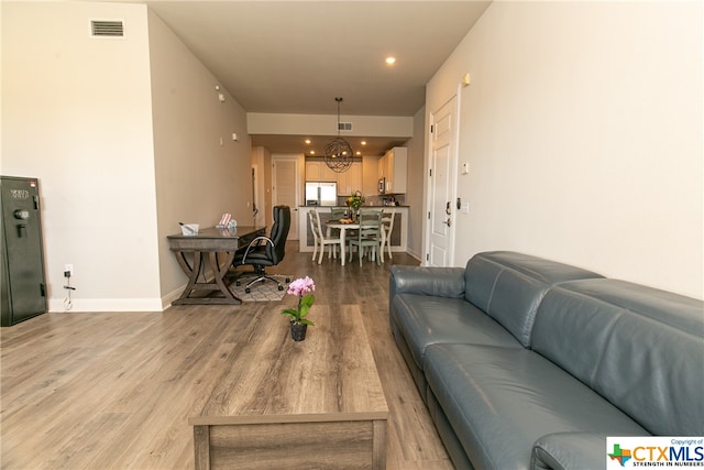 living room featuring light hardwood / wood-style floors and a notable chandelier