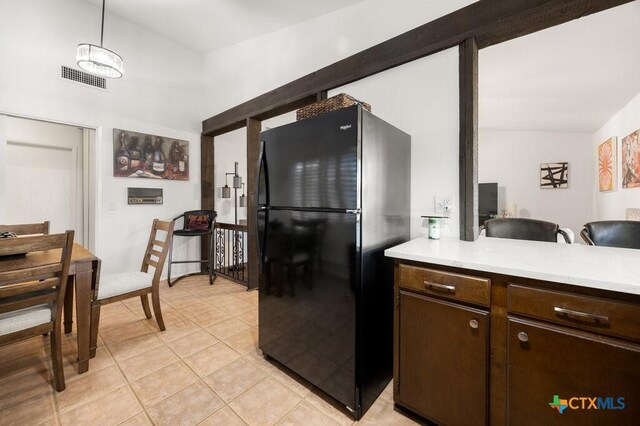 5006 Las Campanas St, San Antonio, TX 78233 - kitchen featuring freestanding refrigerator, light countertops, light tile patterned floors, and dark brown cabinets