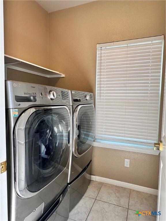 125 Duck Creek Trl, San Marcos, TX 78666 - laundry room with washer and dryer, baseboards, and light tile patterned floors