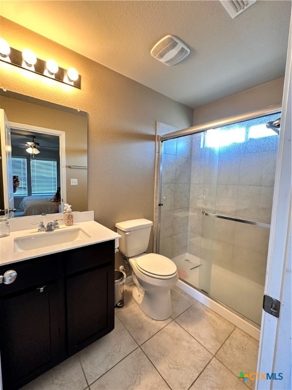 bathroom with toilet, a textured ceiling, ceiling fan, and tile patterned floors