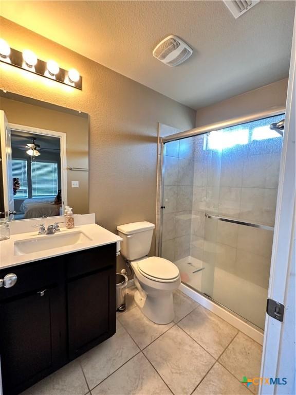 125 Duck Creek Trl, San Marcos, TX 78666 - full bathroom featuring vanity, healthy amount of natural light, a stall shower, tile patterned flooring, and a textured ceiling