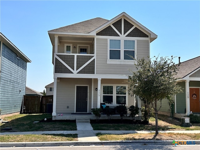 view of front of house with a front lawn, a balcony, and cooling unit