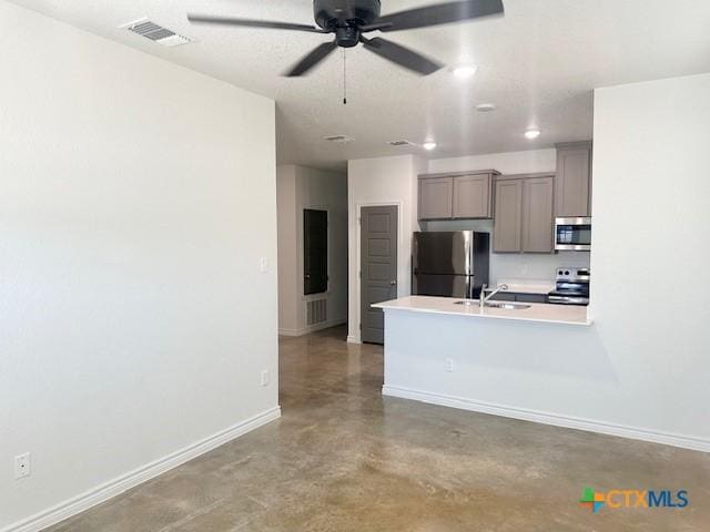2310 Ocean Ave, Temple, TX 76501 - kitchen featuring stainless steel appliances, visible vents, baseboards, gray cabinetry, and finished concrete flooring