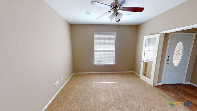 carpeted foyer featuring ceiling fan