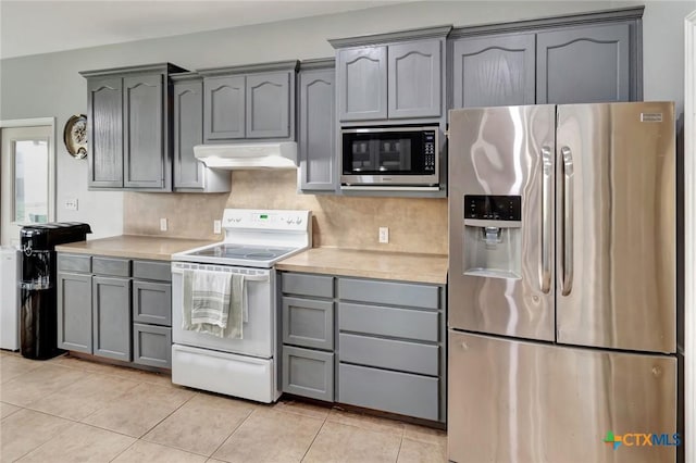 46 Bluestem St, Victoria, TX 77904 - kitchen featuring appliances with stainless steel finishes, under cabinet range hood, gray cabinets, light countertops, and light tile patterned flooring