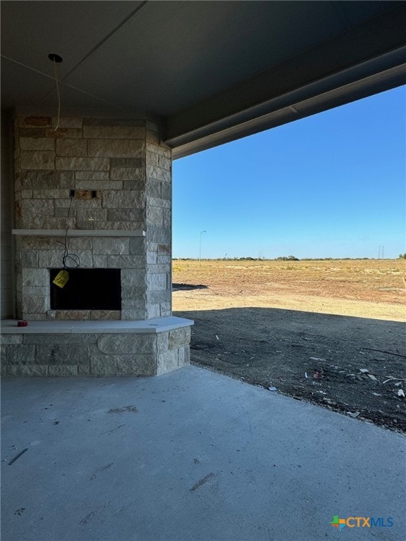 exterior space featuring a patio area and an outdoor stone fireplace