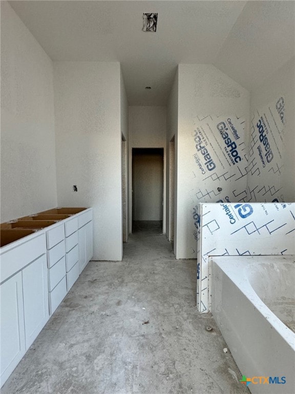 full bathroom with a garden tub and unfinished concrete flooring