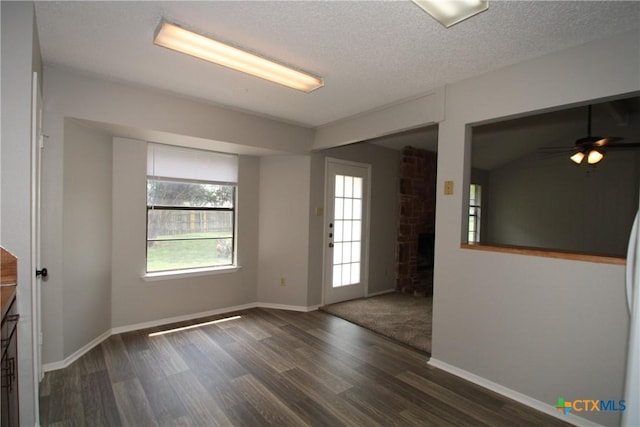4508 Greenbriar Cir, Killeen, TX 76543 - empty room with dark wood-style flooring, a fireplace, baseboards, a ceiling fan, and a textured ceiling