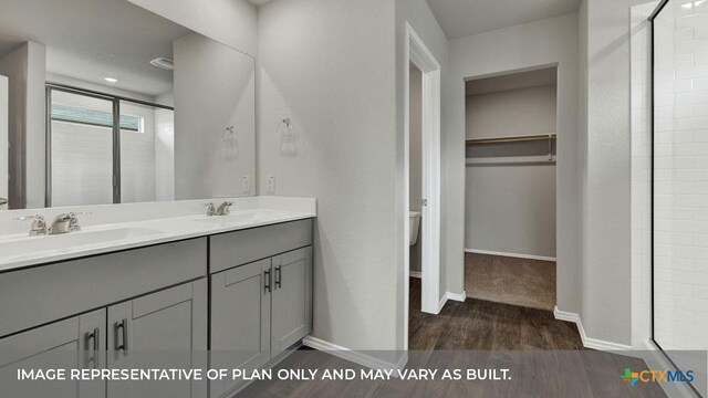 bathroom featuring vanity, hardwood / wood-style flooring, a shower with shower door, and toilet