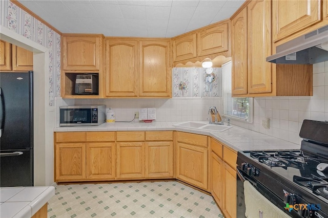 kitchen with black appliances, ventilation hood, sink, and light brown cabinetry