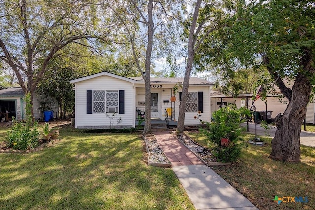 view of front of house with a front yard, a porch, and cooling unit