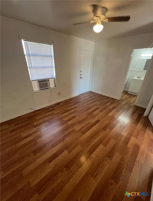interior space with baseboards, a ceiling fan, wood finished floors, and cooling unit