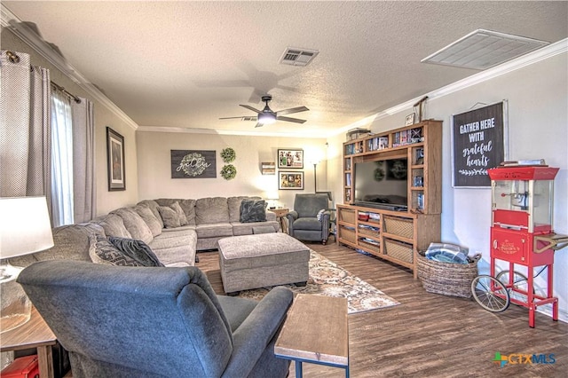 living room with ceiling fan, ornamental molding, dark hardwood / wood-style flooring, and a textured ceiling