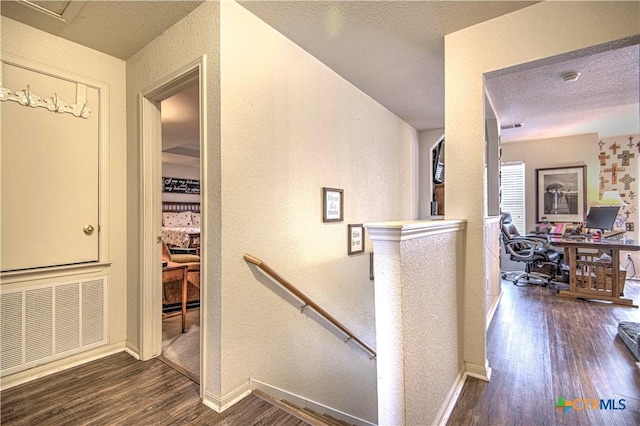 corridor with dark wood-type flooring and a textured ceiling