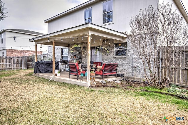 back of house with a yard and a patio